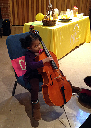 Miss “Bumblebees!” checks out the cello at an instrument petting zoo after the show.
