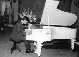 Photo of young Ziegler playing white grand piano