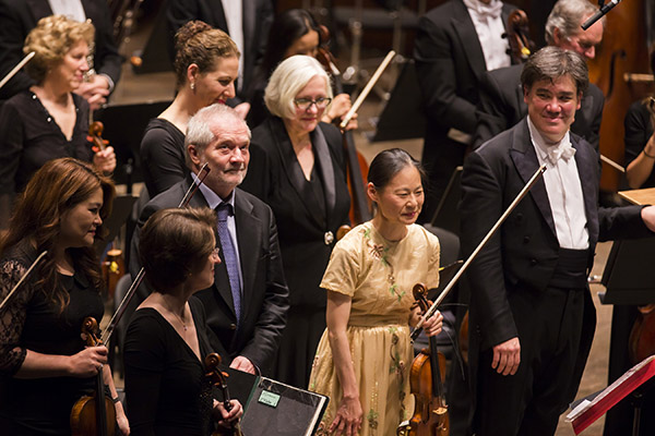 Composer Péter Eötvös and soloist Midori acknowledge the crowd after a performance of <em>DoReMi </em> for violin and orchestra.