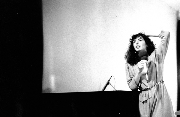 Shelley Hirsch singing into microphone.