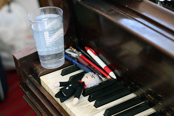 keyboard of piano with pens and toy on top
