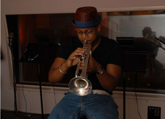 Etienne Charles playing trumpet in a recording studio