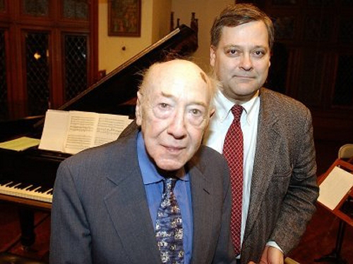 David Diamond and Daron Hagen wearing jackets and ties and standing in front of a piano.
