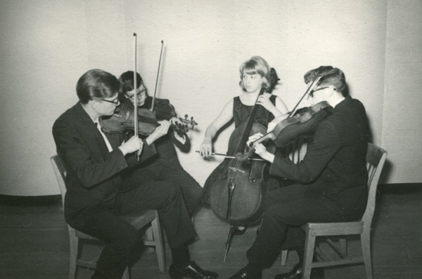 Historic B&W photo of Jacovin String Quartet playing their instruments.