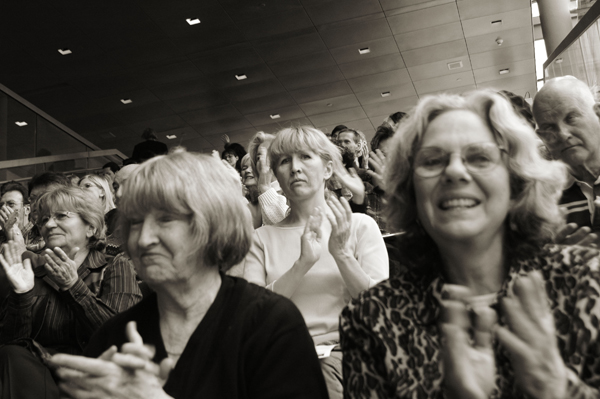 Audience members in a concert hall applauding