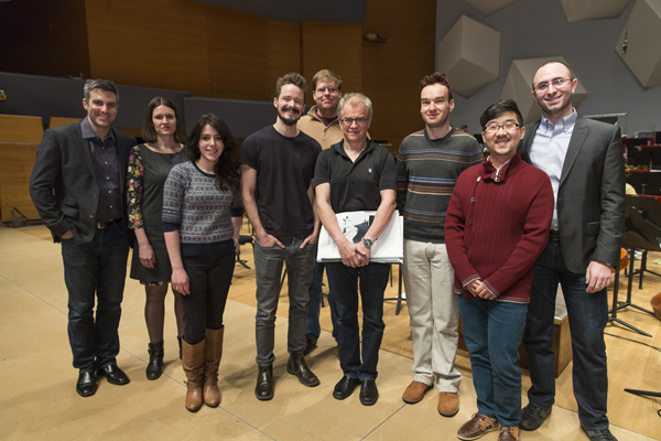 The seven featured Minnesota Orchestra composers, Kevin Puts and Osmo Vanska standing on the stage of Orchestra Hall.