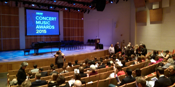 The stage of Merkin Concert Hall with a screen projecting "2015 ASCAP Concert Music Awards" and some people in the audience.