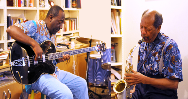 Jamaaladeen Tacuma playing an electric bass and Ornette Coleman playing alto saxophone in an apartment. 