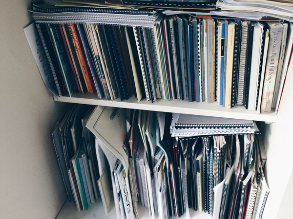 Piles of musical scores somewhat in disarray on shelves.