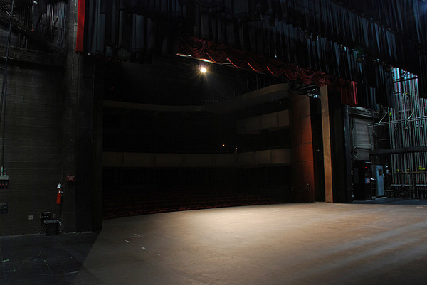 Photo of a dimly lit empty stage.
