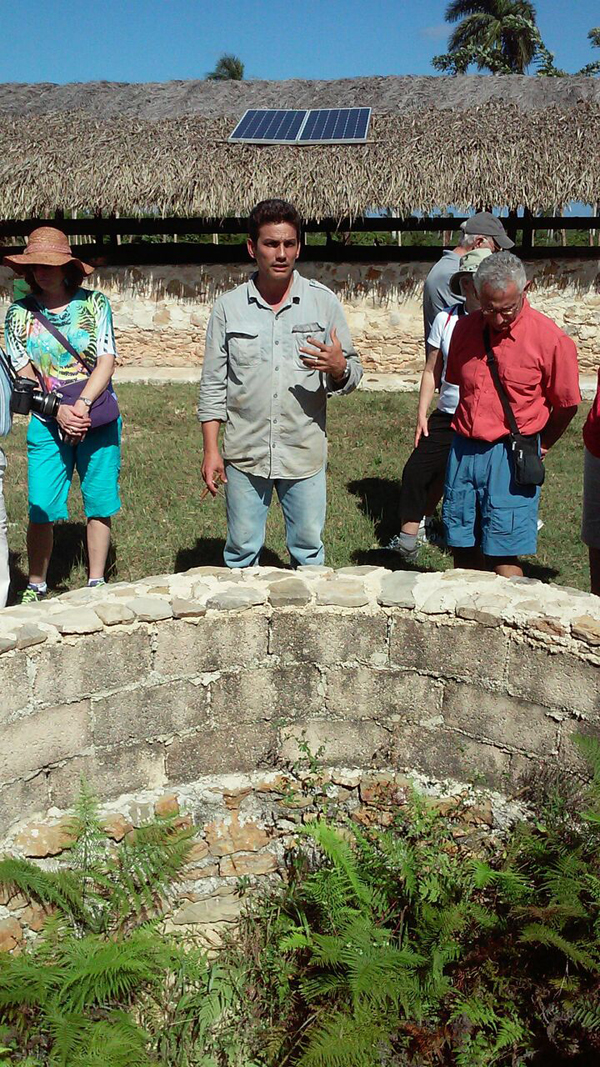 Fernando and others stand around a well.