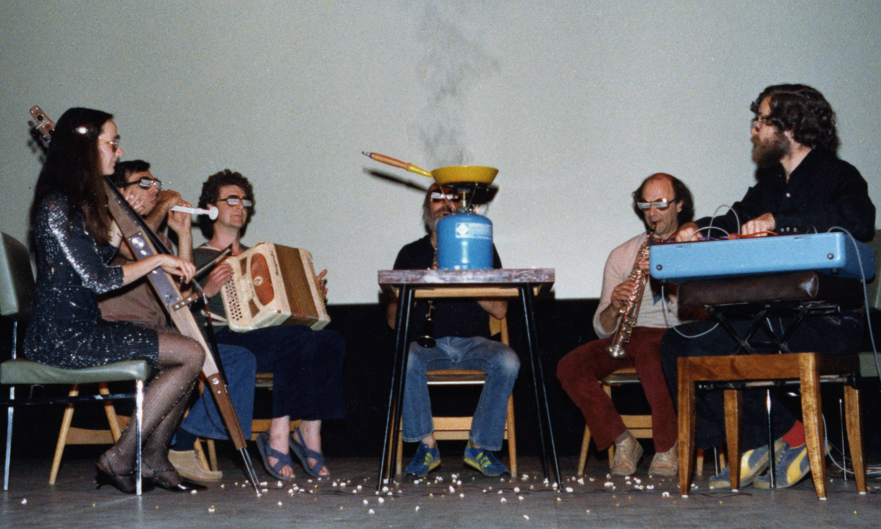 A group of six musicians playing very bizarre looking instruments.