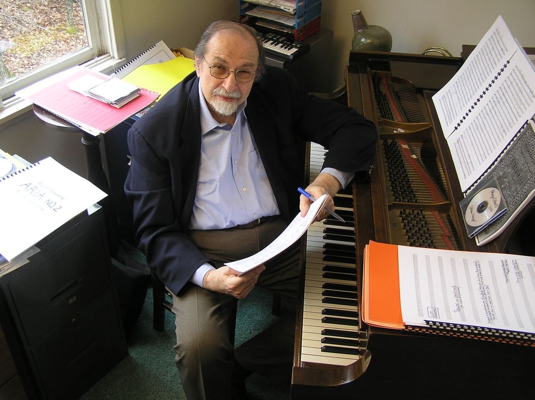 Elliott Schwartz at the piano surrounded by scores of his music.