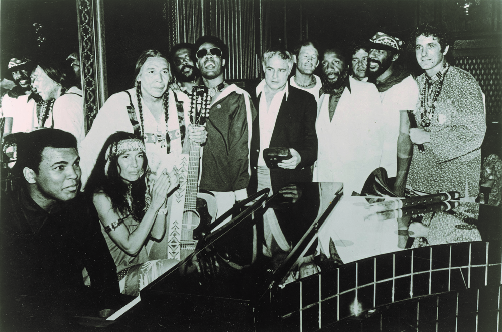 A group photo from 1978 at the end of The Longest Walk, a 3,800 mile protest March from San Francisco to Washington, D.C. Muhammed Ali sits at far left, and at the far right is David Amram. Marlon Brando is at the center, sandwiched between Stevie Wonder and Dick Gregory. 