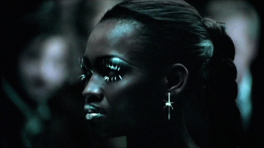 A still from the Cadillac Super Bowl ad scored by COPILOT featuring a n almost robotic-looking female model with prominent silver lipstick and eyeliner as well as a silver earring