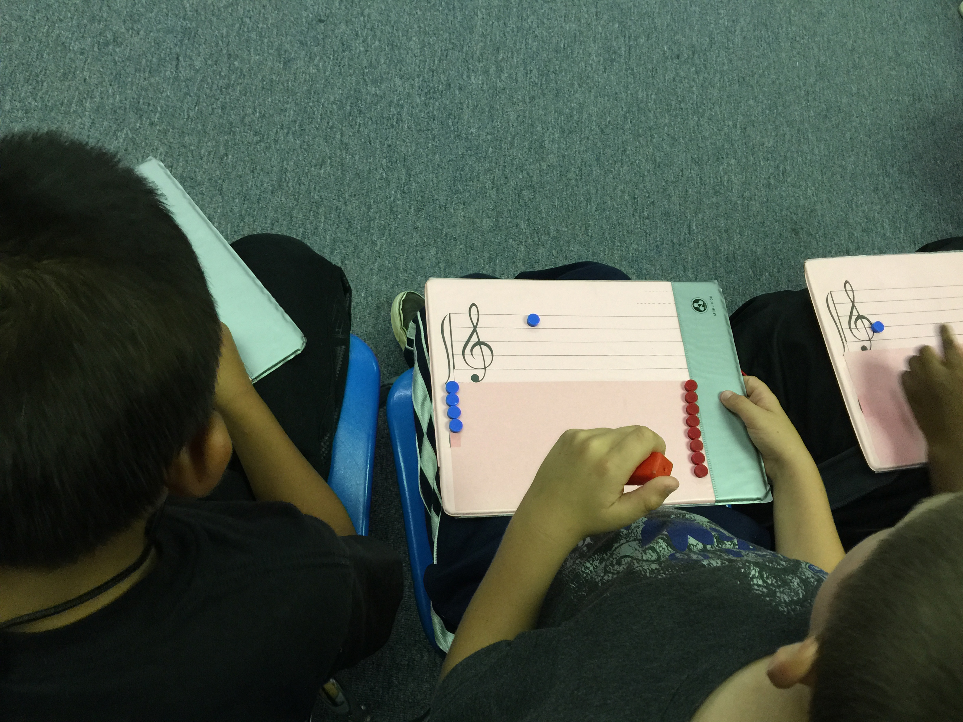 Students in music class working with a tool to assist in learning musical notation.