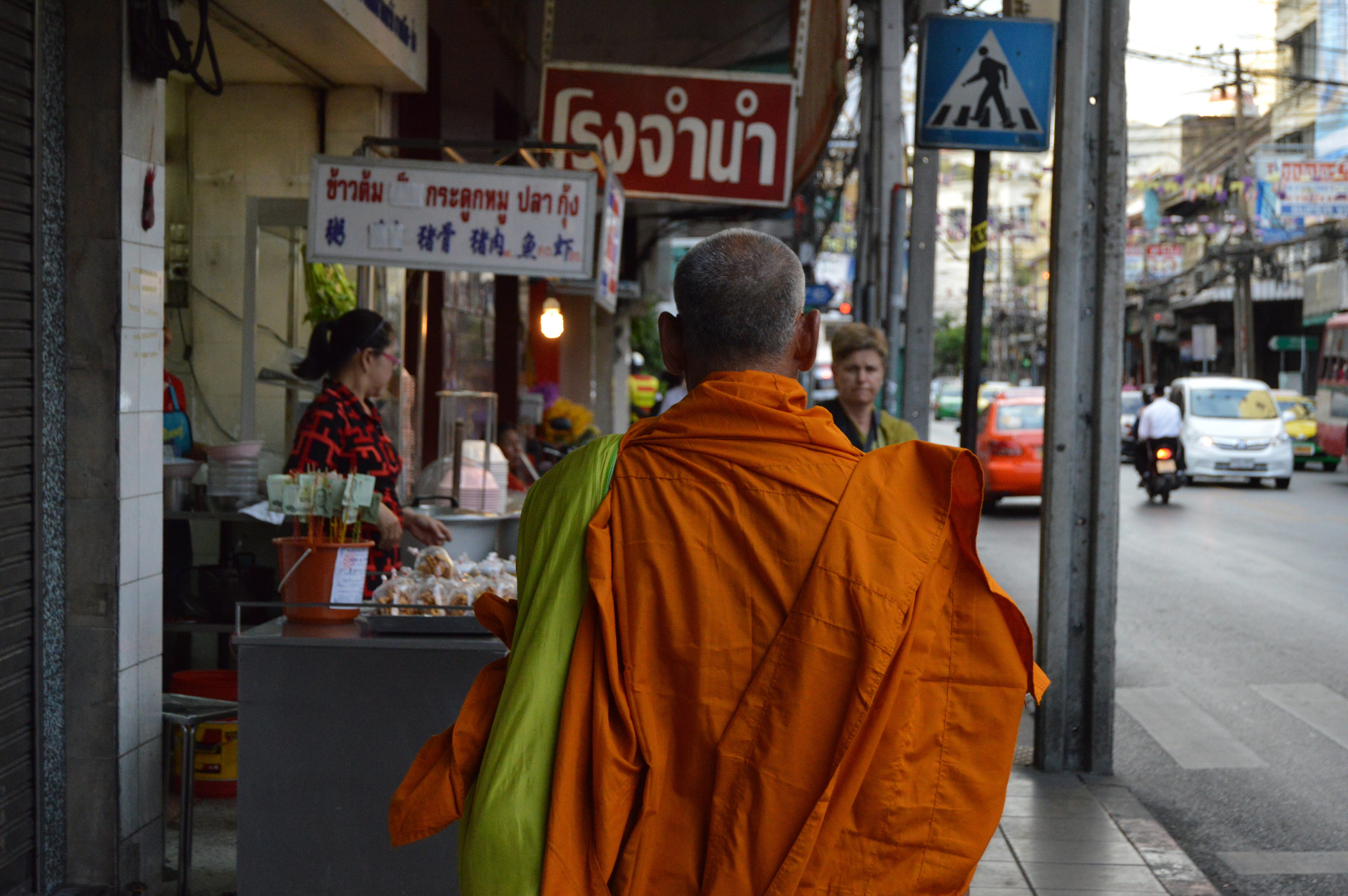 A monk walking down a street in Bangkok.