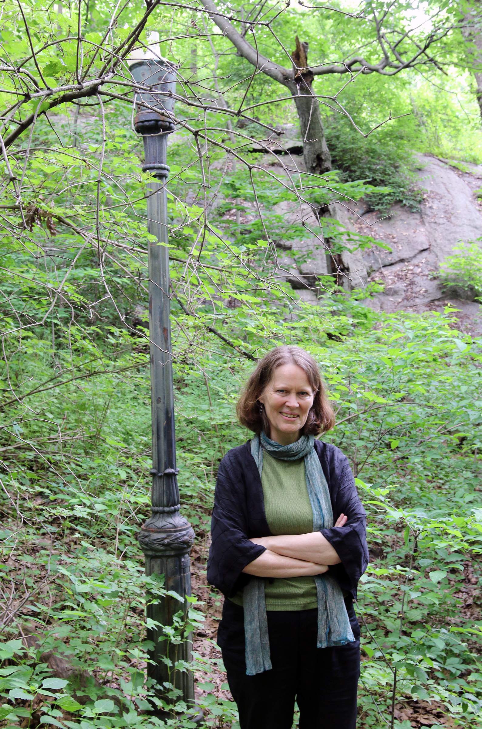 Kristin Norderval standing by a broken light post in Inwood Hill park