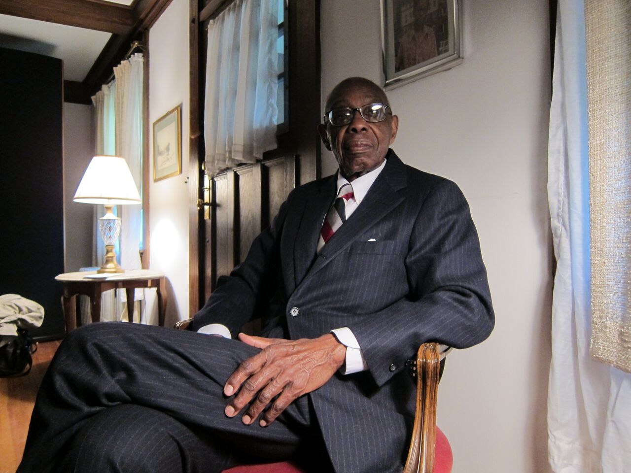 George Walker sitting in a chair in his living room.