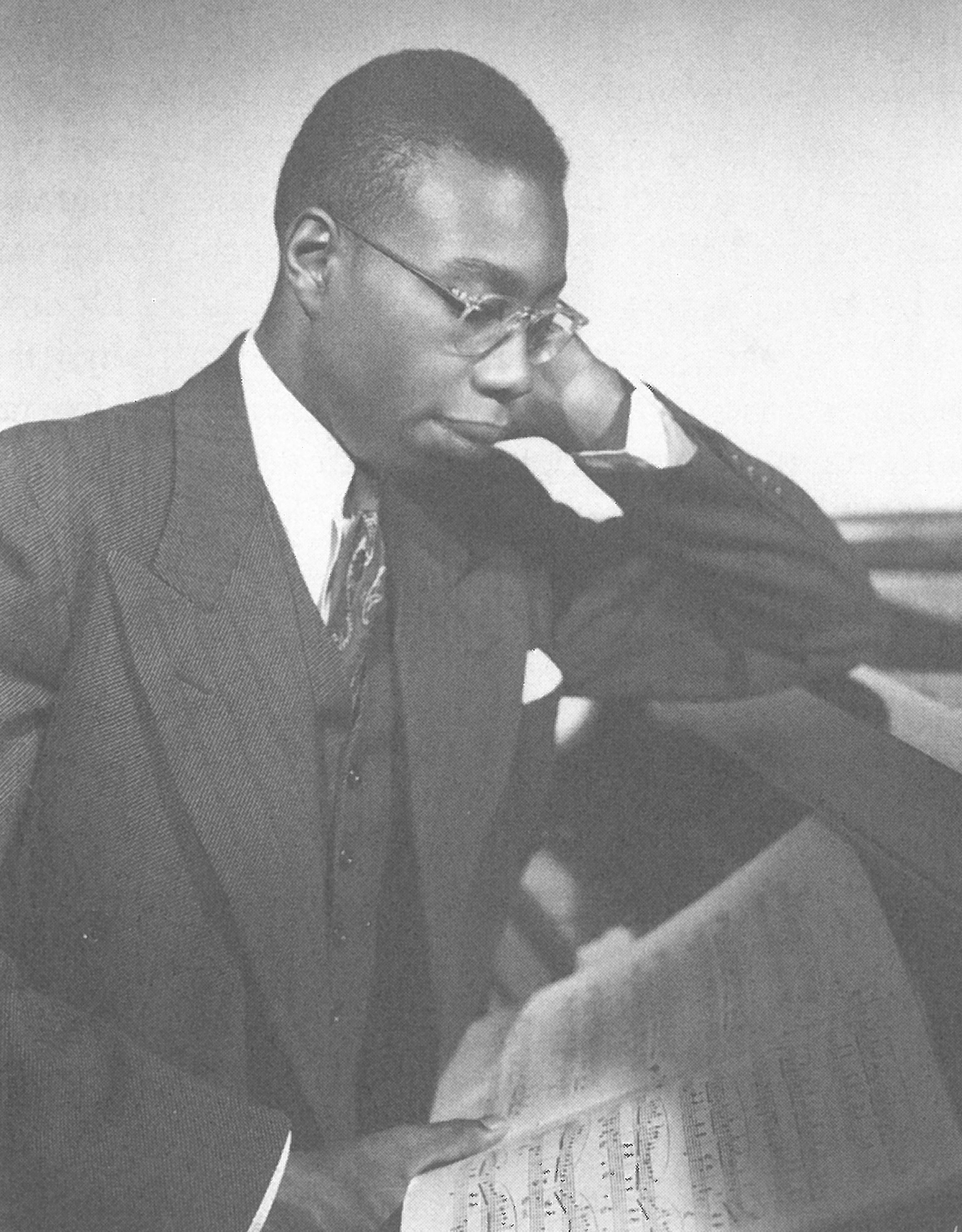 George Walker at a piano pensively studying a score in 1941.