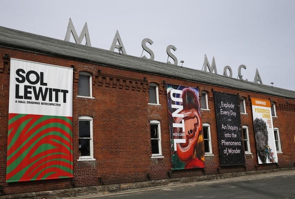 One of the outside walls of MASS MoCA which is partially covered with posters for exhibitions: Sol Lewitt, Federico Urbe, UNTL.