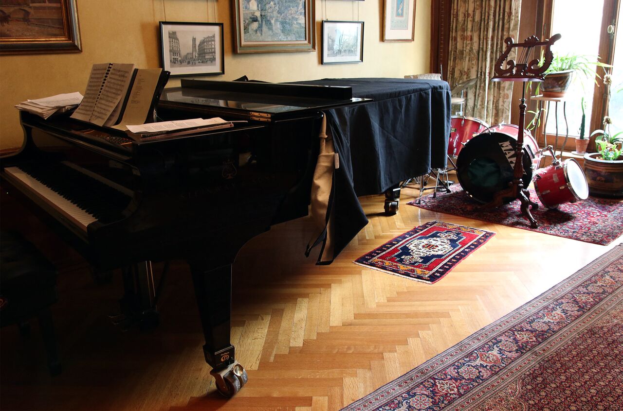 A grand piano and a drum set are side by side in Stefania de Kenessey's living room.