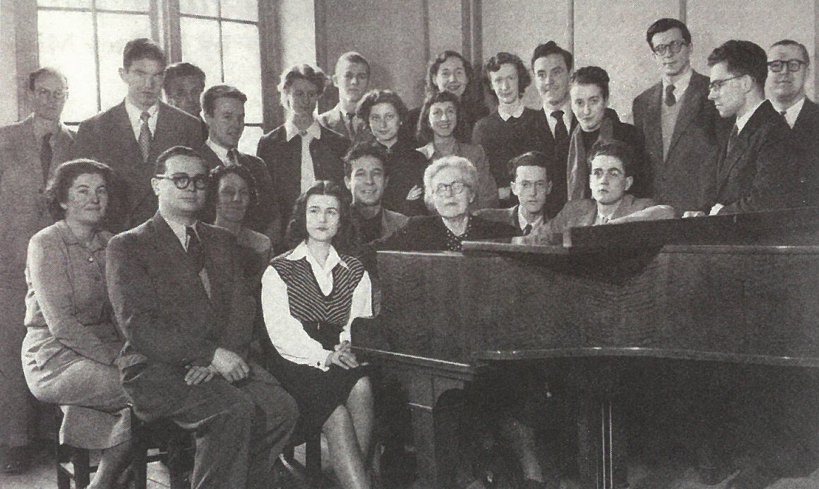 Nadia Boulanger (seated in front of a piano) with a large group of students.