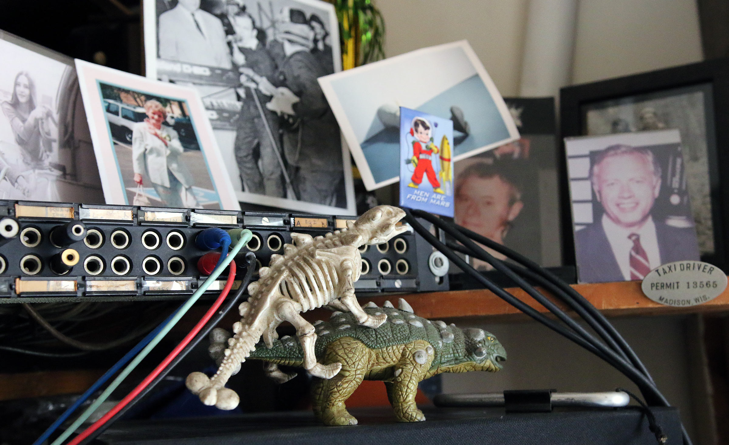 A couple of plastic dinosaurs and old photos surrounding some of Scott Johnson's electric keyboards.