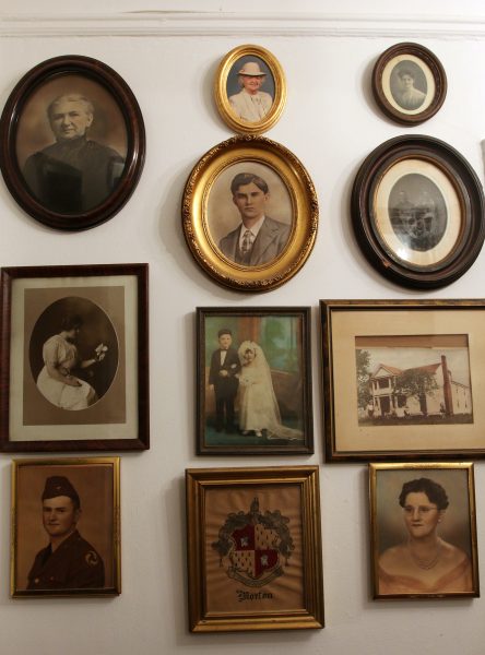 Framed photos of various members of Beth Anderson's family hang on a wall near the entrance to her apartment.