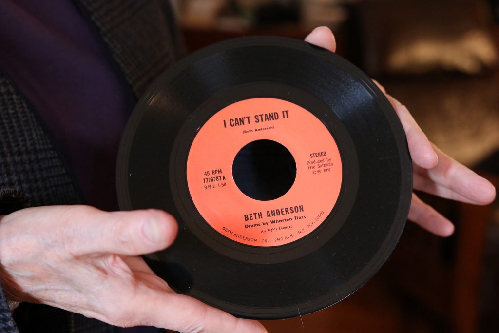 Beth Anderson holding the original 45rpm recording of her text sound piece "I Can't Stand It" which she performed with drummer Wharton Tiers.