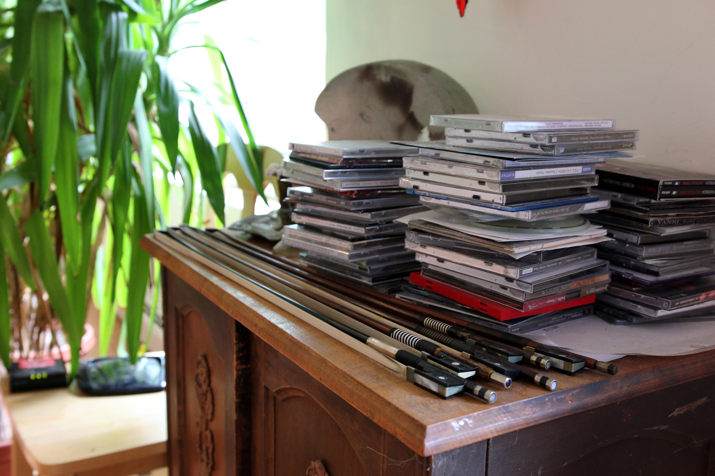 A pile of CDs and violin bows on a table in George Tsontakis's home.