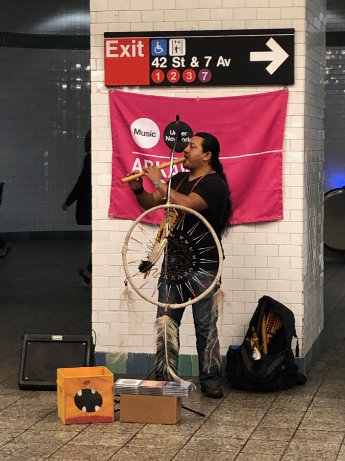 A musician performing in one of the walkways between platforms at the Times Square station.