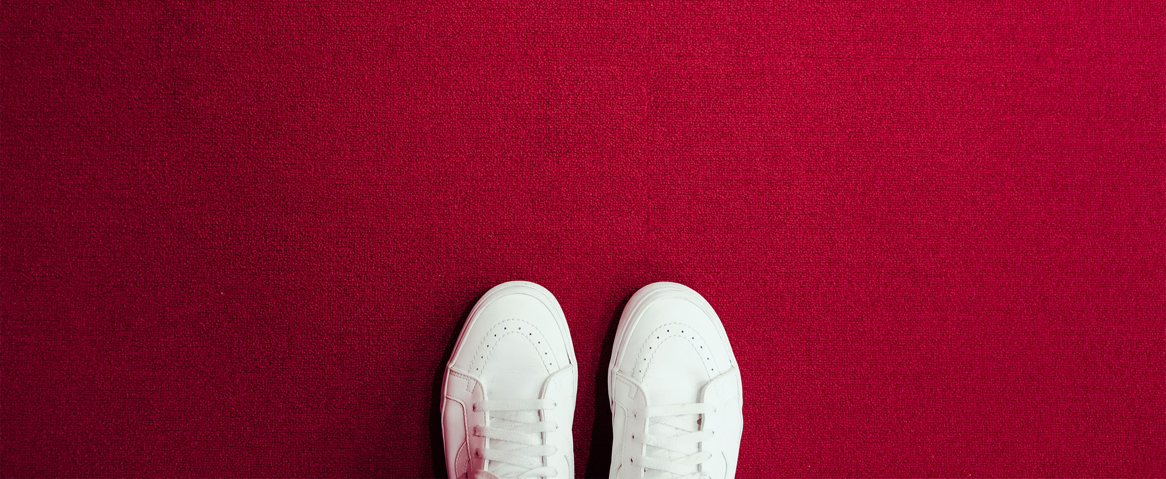 white shoes ready to step forward on red carpet