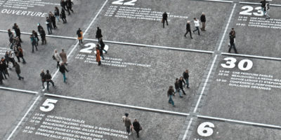 A street at the Centre Pompidou in Paris on which I calendar grid has been painted showing people walking through various days 