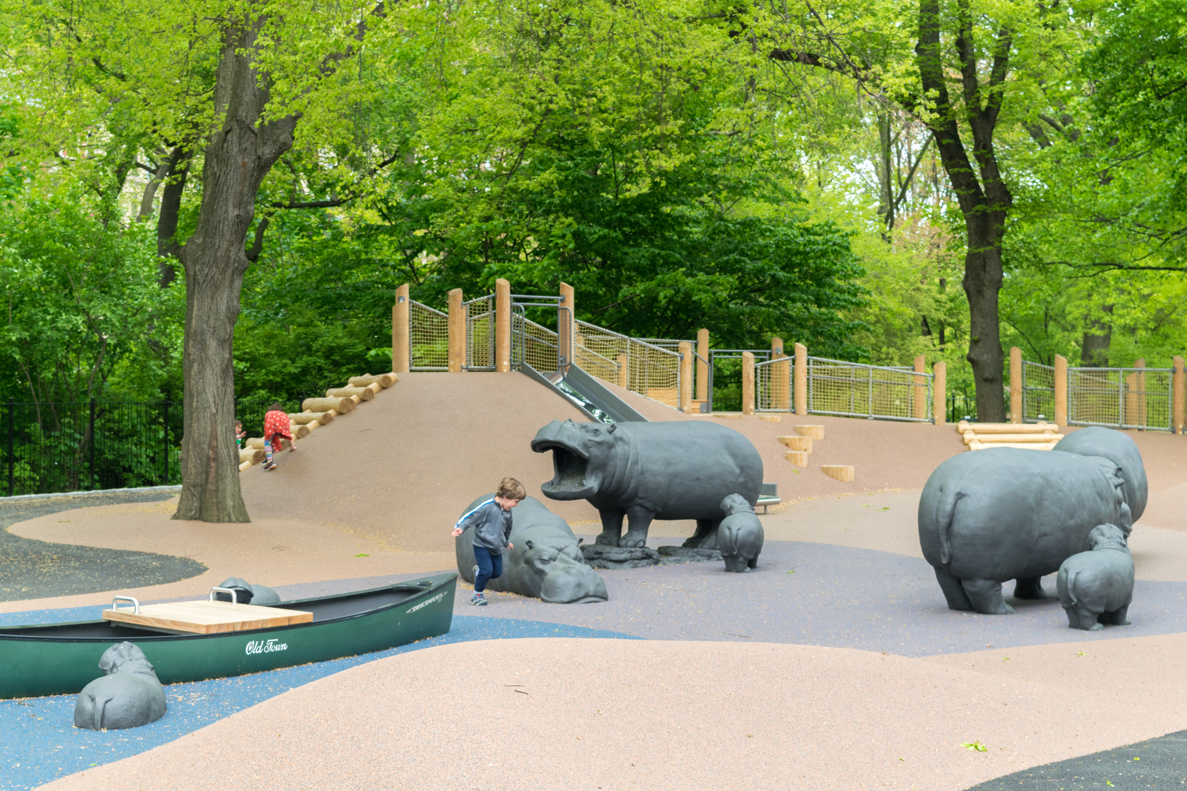 A child wandering around sculptures of hippopotami and a fake rowboat in Central Park's Safari Playground. (photo courtesy of the Central Park Conservancy)