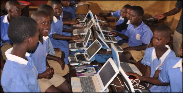 Young uniformed Ugandan students sitting in front of computer terminals.