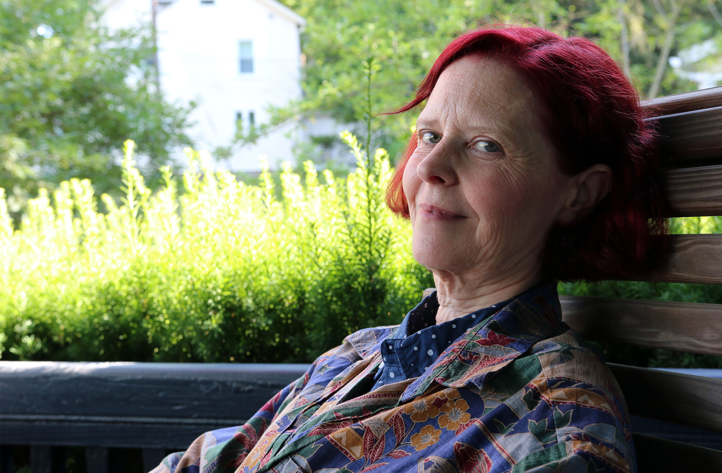 A photo of a woman with red hair sitting outdoors