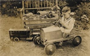 Ben Johnston as a child driving a toy car.