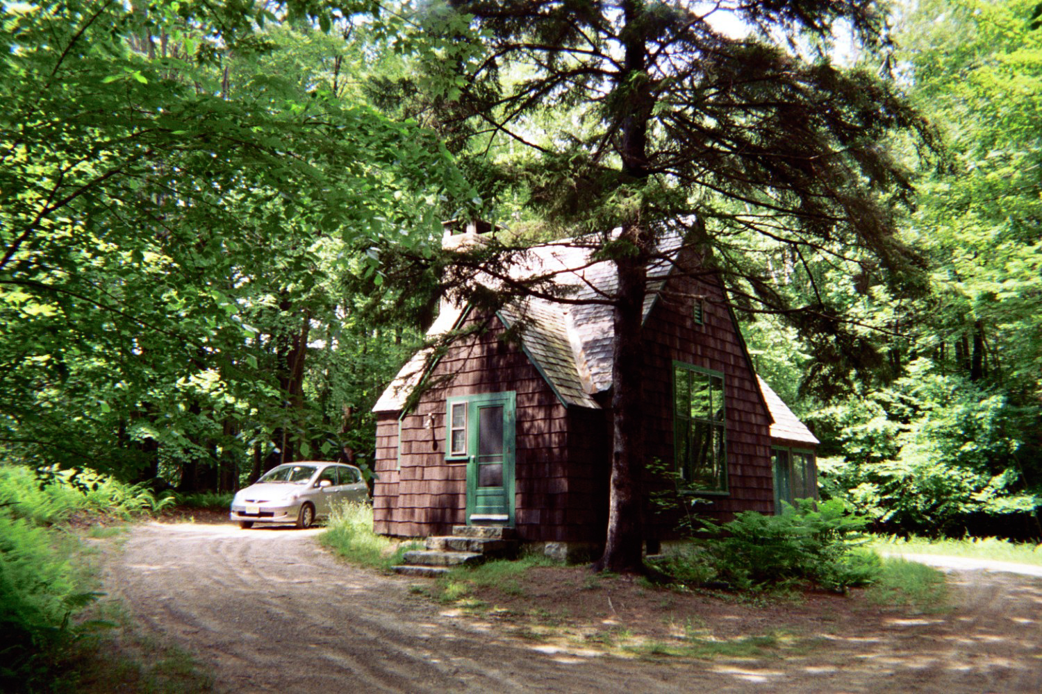 A car approaching a wooden cabin