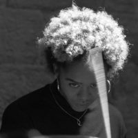 Romarna Campbell playing a drum set