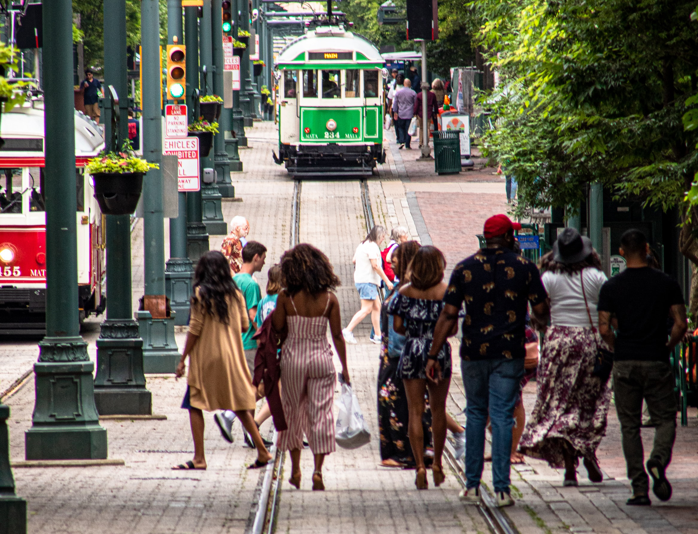 People walking on the tracks toward a streetcar in Memphis, TN, (Photo by Joshua J. Cotten / Unsplash)
