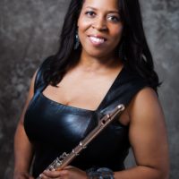 A BIPOC woman posing with a flute