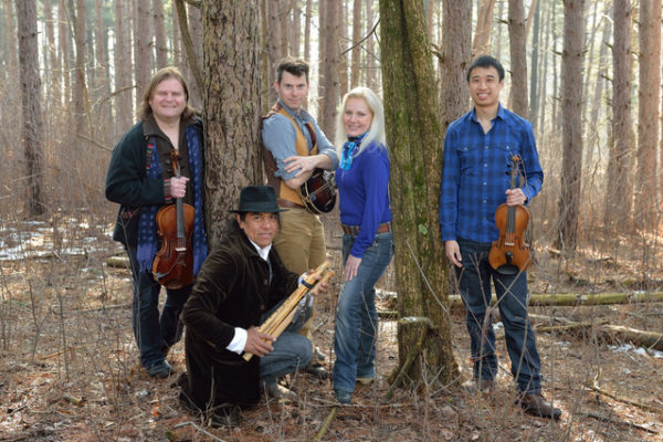 Five performers standing in the woods