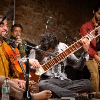 Musicians in the Brooklyn Raga Massive, including a violinist and a sitar player