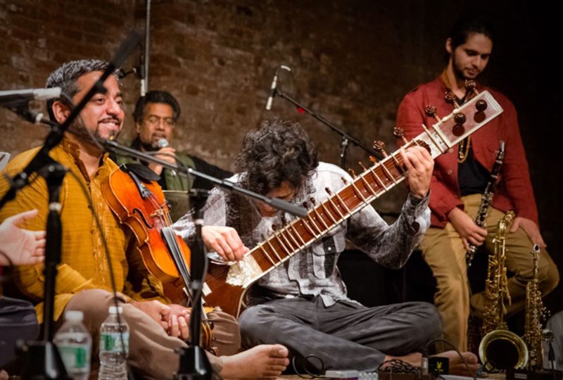 Musicians in the Brooklyn Raga Massive, including a violinist and a sitar player