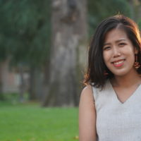 outdoor shot of an AAPI woman in a cream, v-neck top