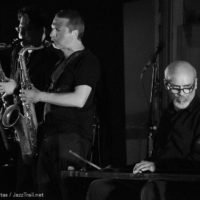 Black and white photo of a saxophone player and a percussionist