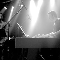A marimba and saxophone player perform on a stage.