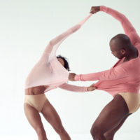 Two dancers tug at each other's clothes