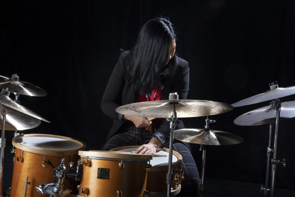 Susie Ibarra playing a drum set.